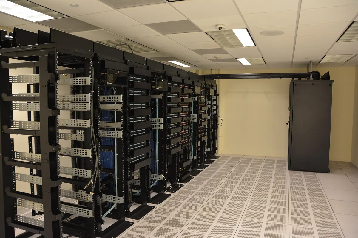Rows of black server racks inside a data center room